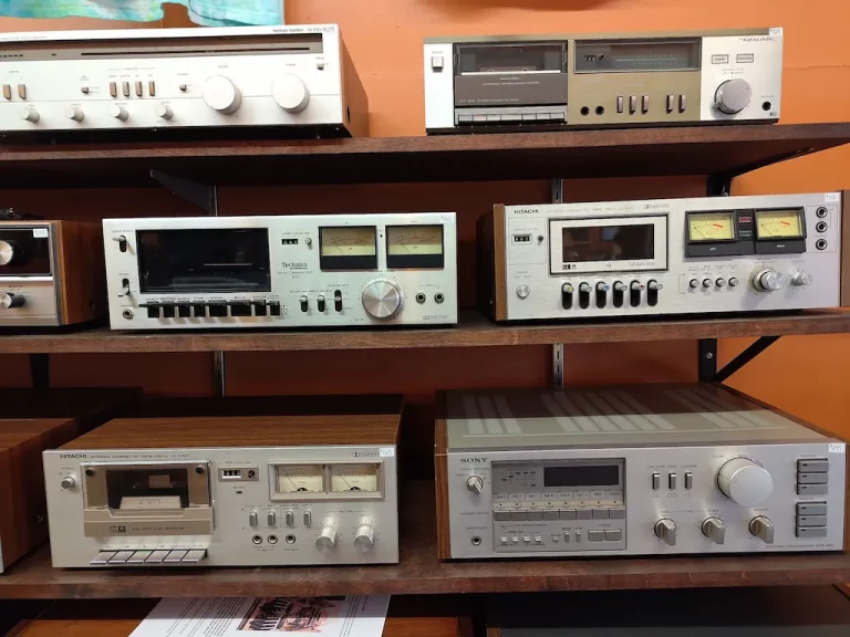 a rack of various vintage hifi stereo receivers that have been either repaired or bought and sold